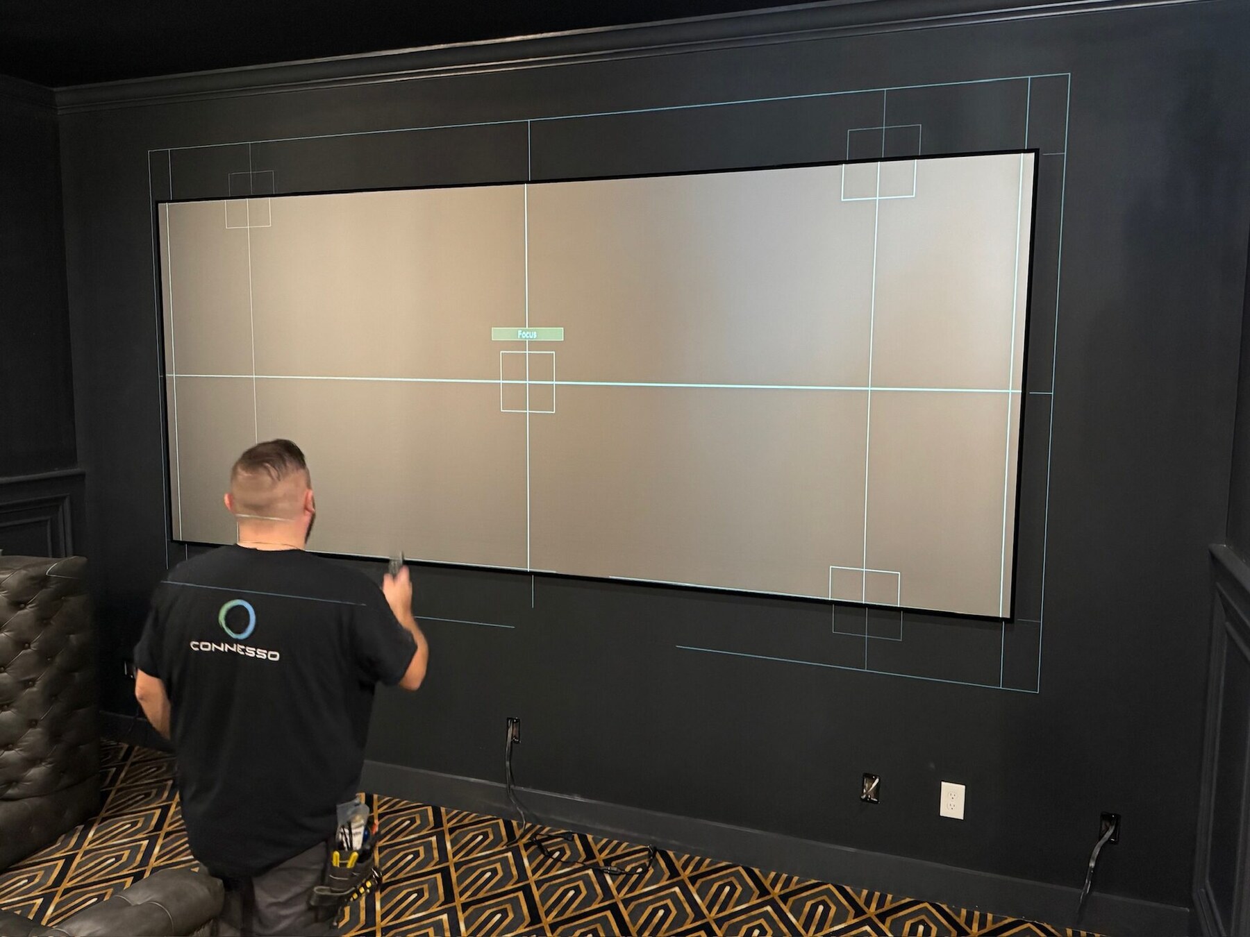 Connesso technician calibrating a home theater projection screen