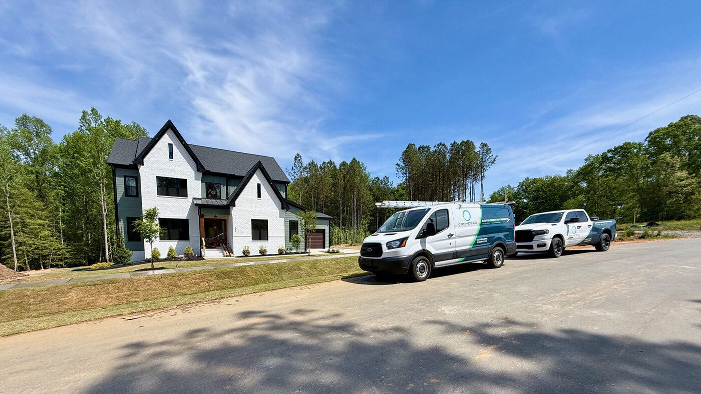 Connesso branded van and pickup truck parked at a modern farmhouse custom home
