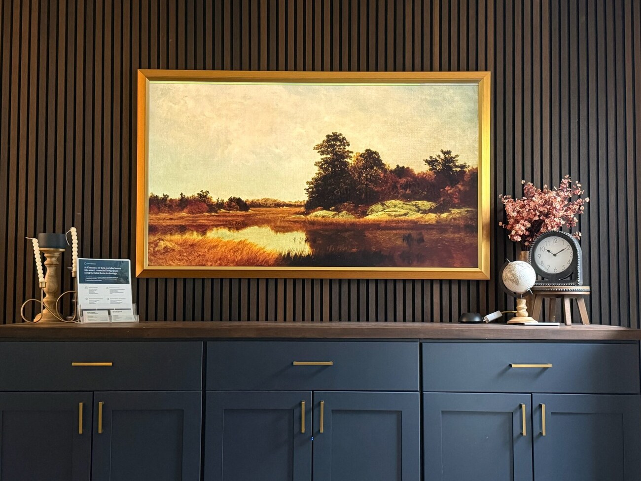 Gold-framed Frame TV in art mode on a slatted accent wall
