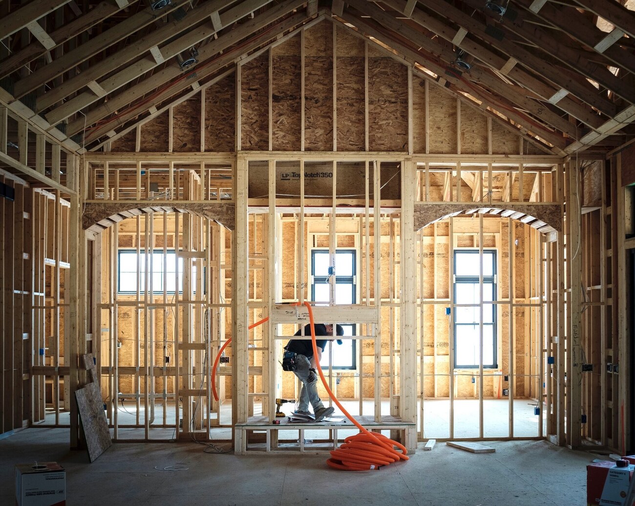 Connesso technician running low-voltage prewire through wood framing