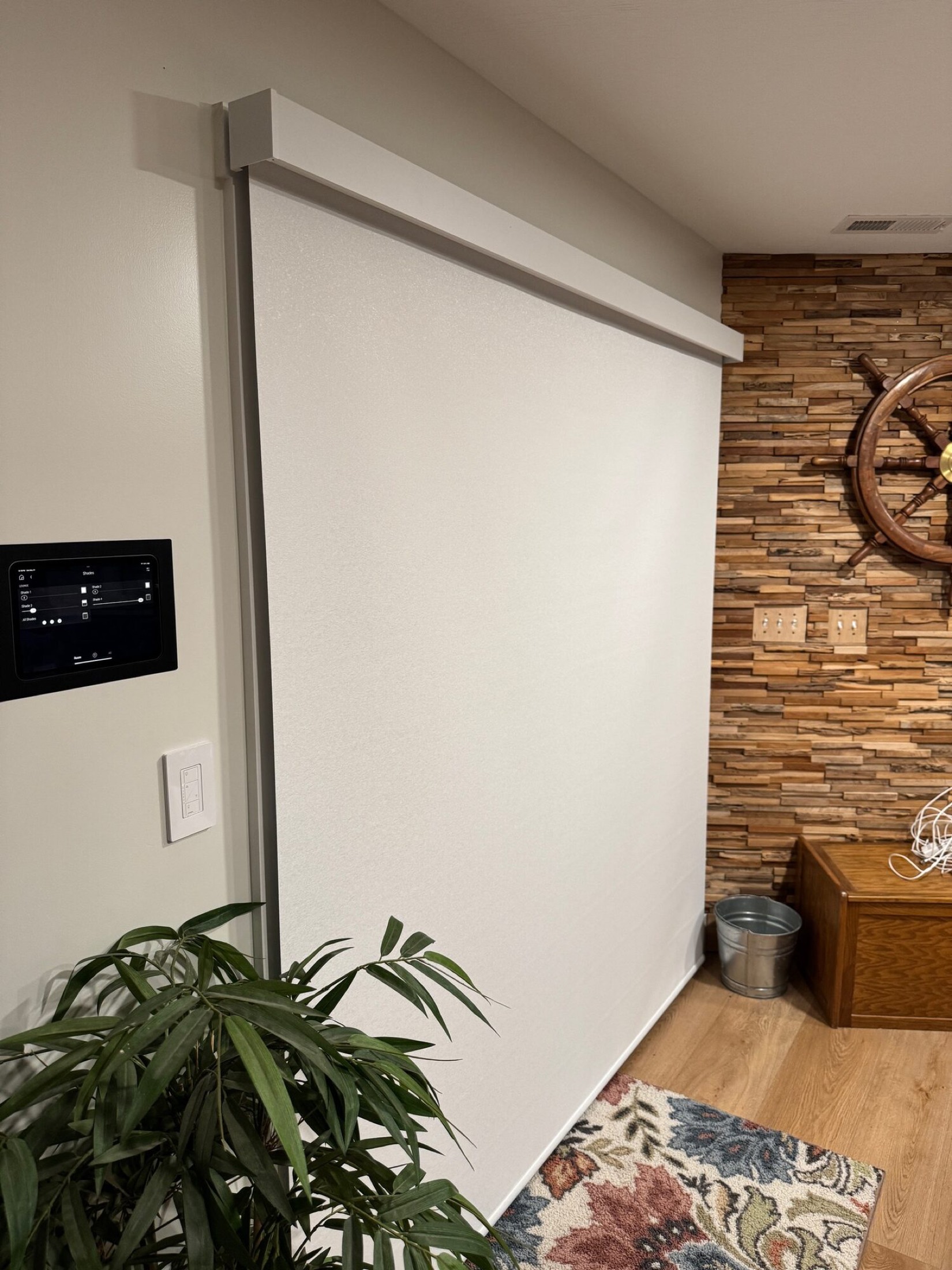 Control4 touchscreen controlling a motorized projection screen in a media room