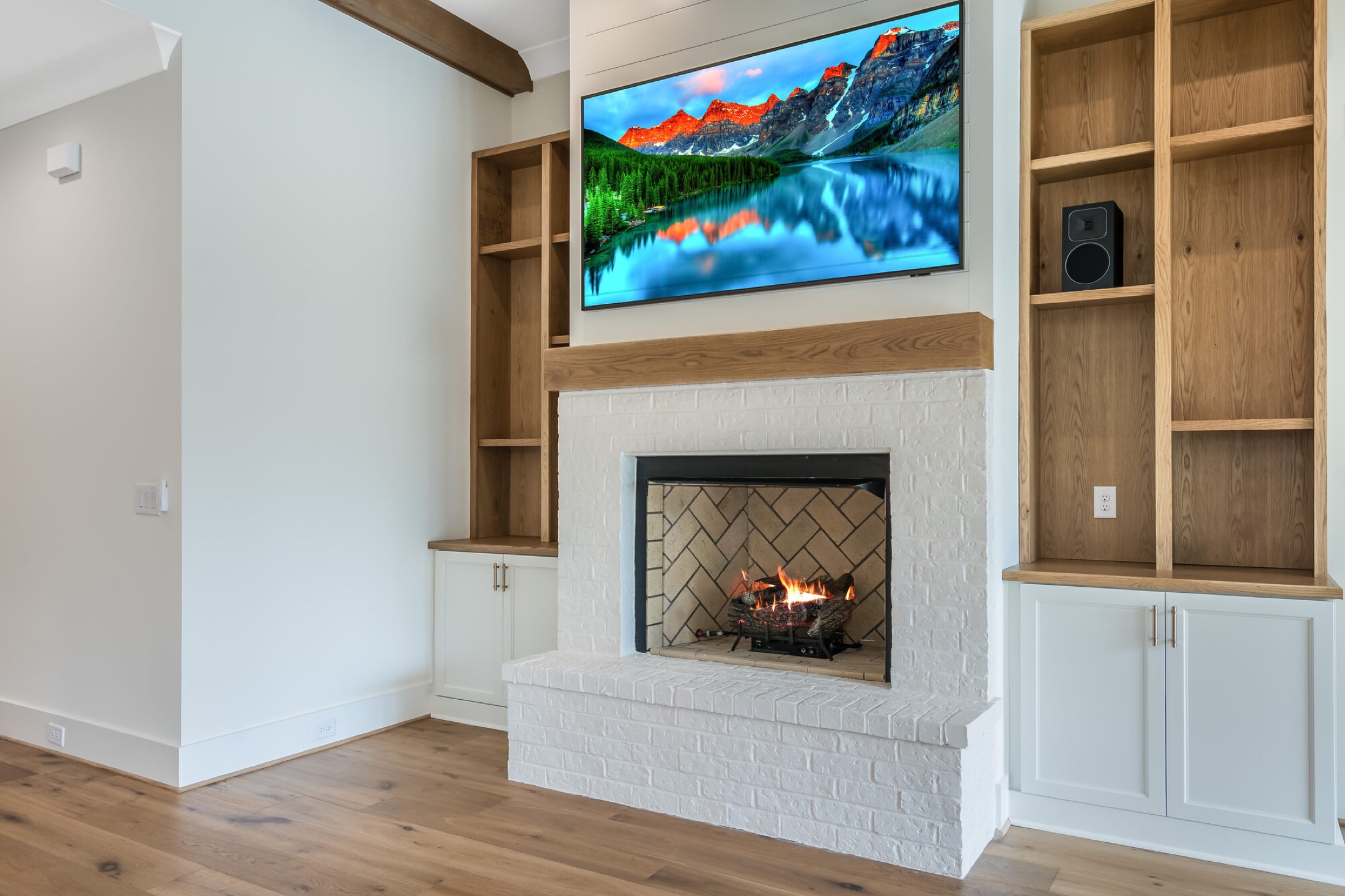 Control4 smart home control in a Columbus great room with a wall-mounted TV, stone fireplace, and oak built-ins