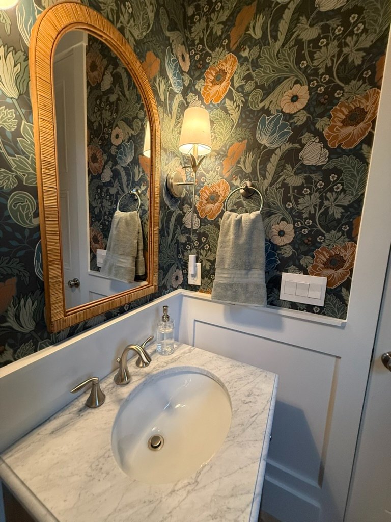 Deako smart lighting switch beside a marble vanity in a finished powder room