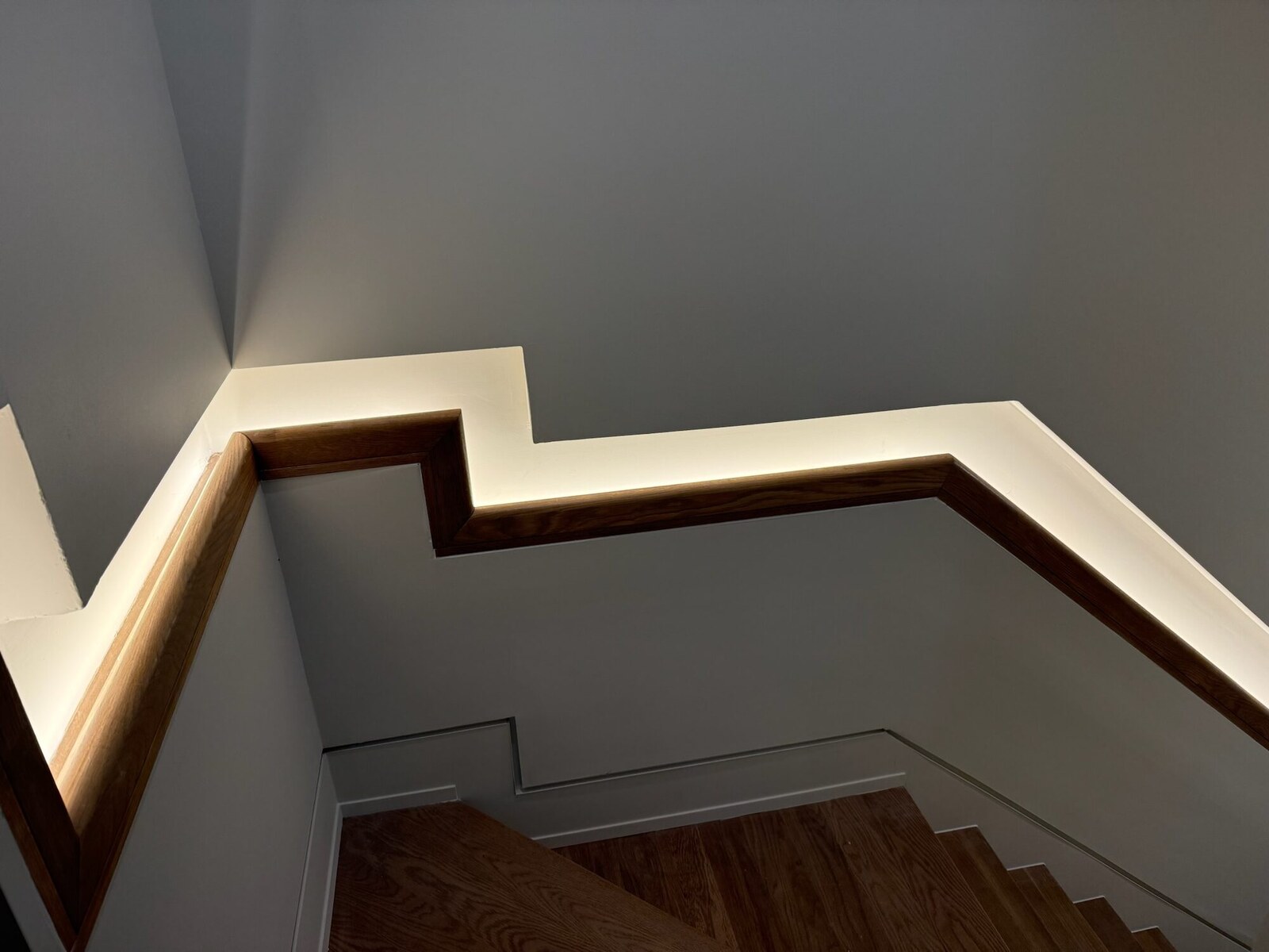 Wood handrail with integrated LED cove lighting along a staircase, Apex NC
