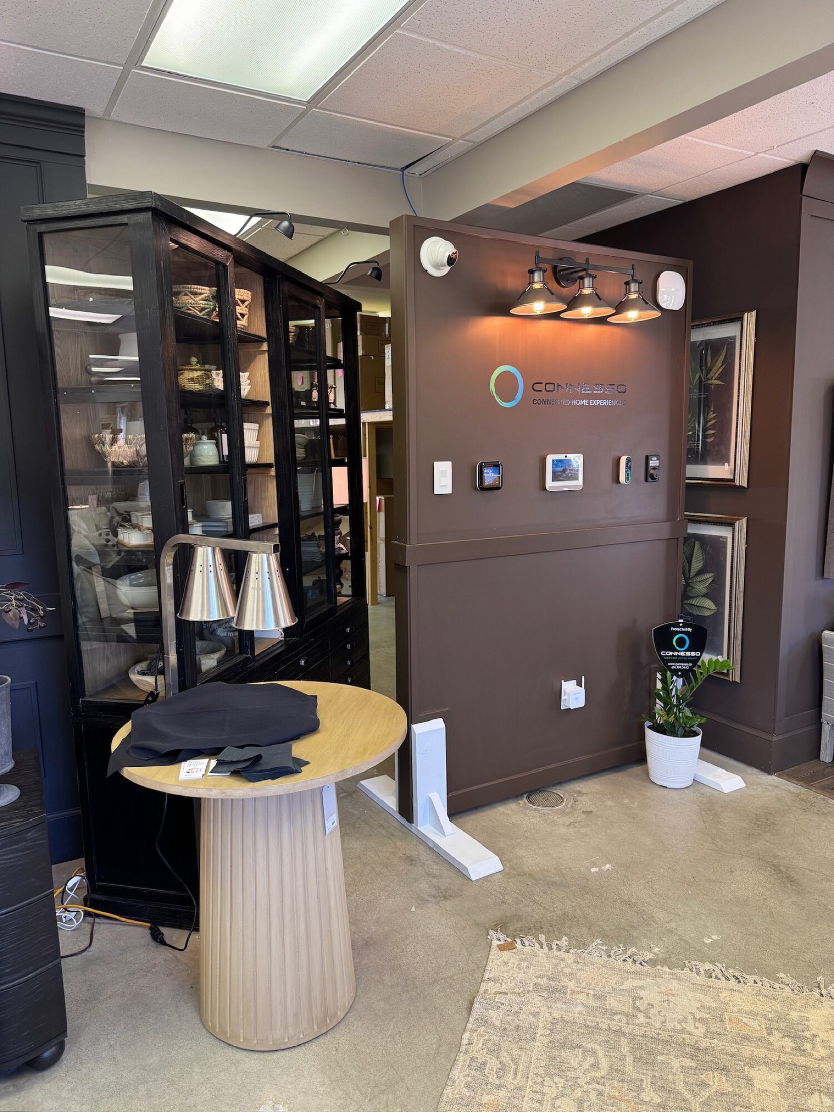 Showroom wall with a Lutron keypad, smart thermostat and home control panel side by side