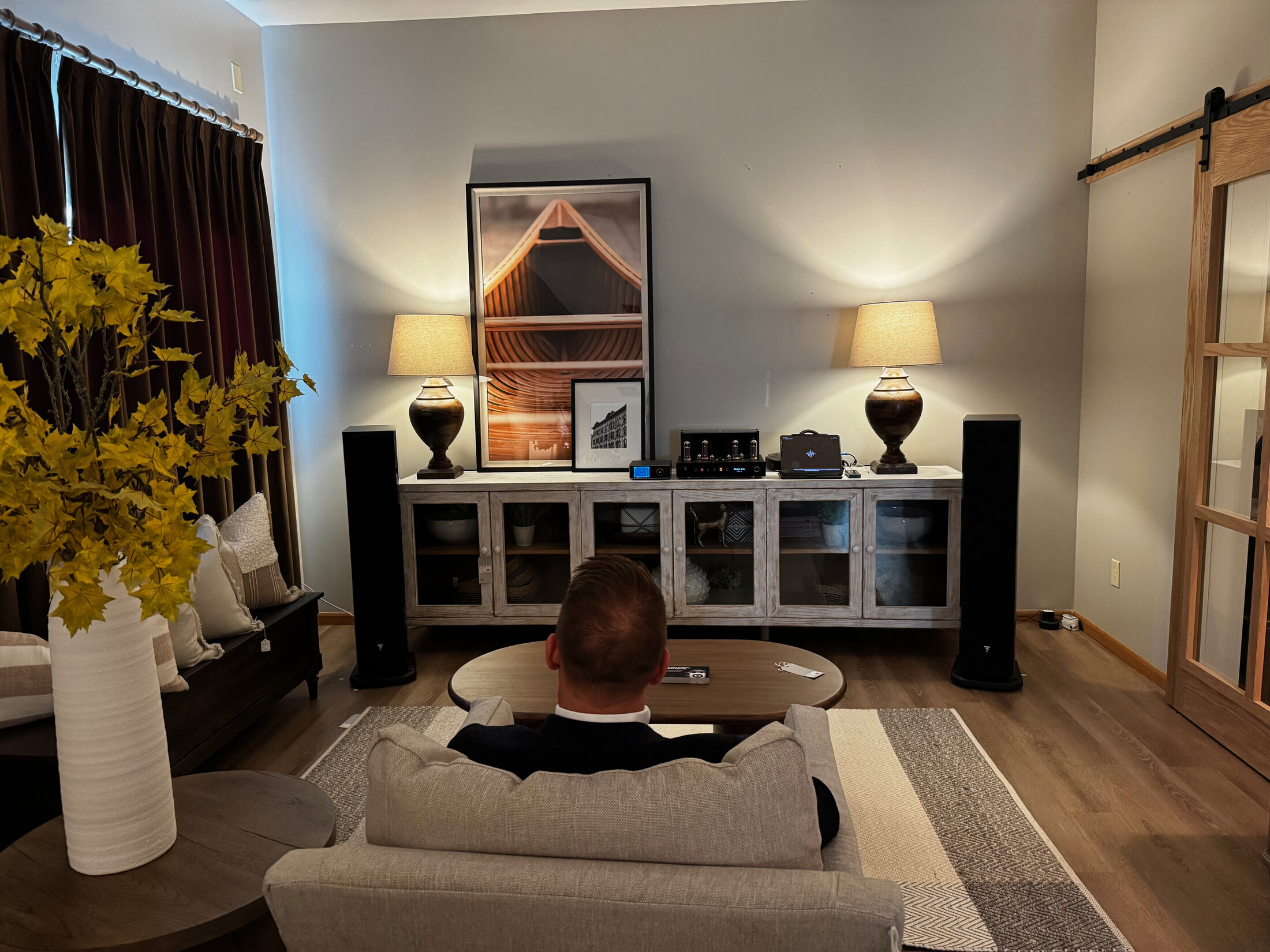 Two-channel listening room with tower speakers, tube amplifier, and a single chair