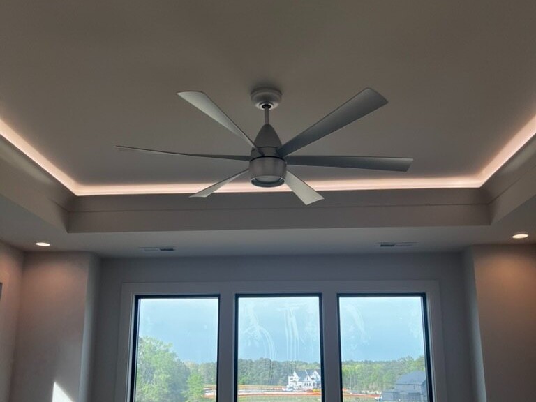 Cove lighting washing a tray ceiling above a window with a lake view, Raleigh NC