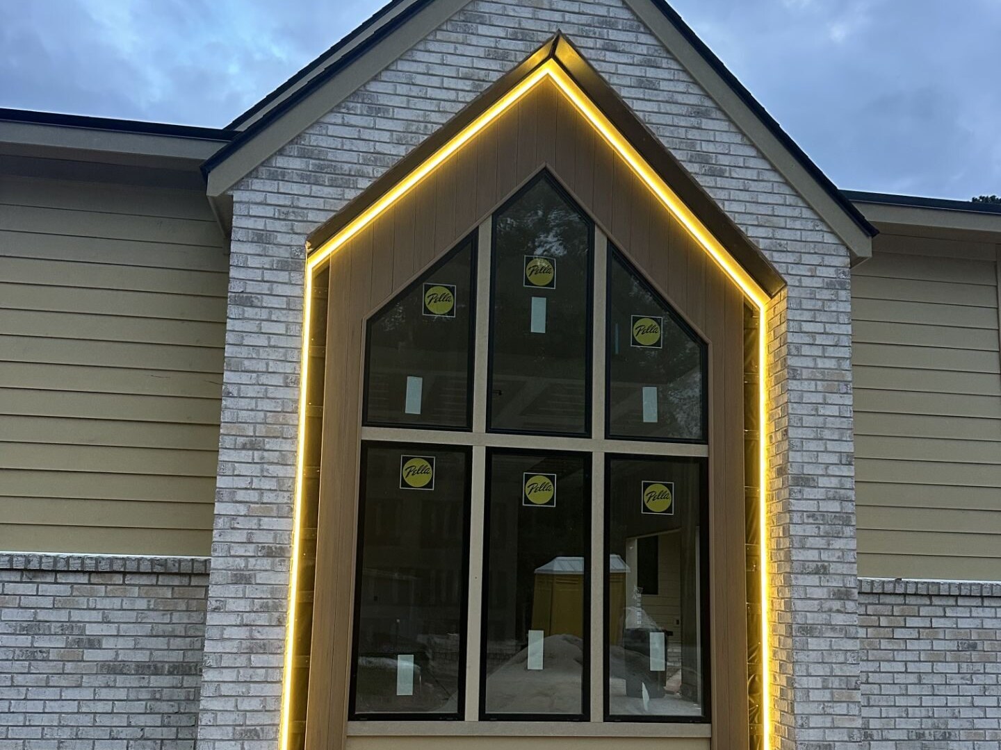 Warm LED accent lighting outlining a gable peak and window surround at dusk, Durham NC