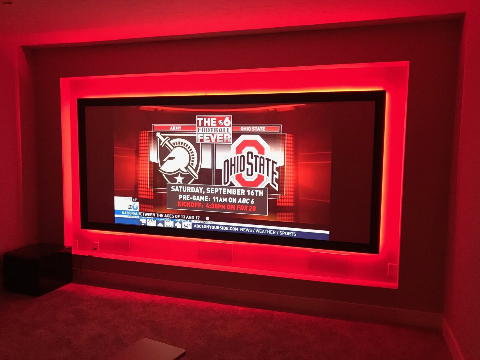 Dedicated home theater with a large projection screen and vivid red LED accent lighting, Columbus OH