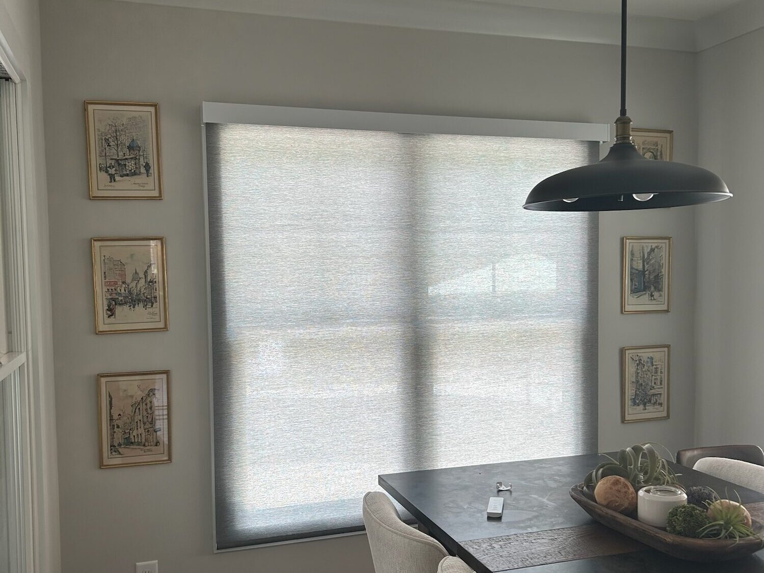 Motorized roller shade lowered in a dining nook with pendant lighting, Pinehurst NC