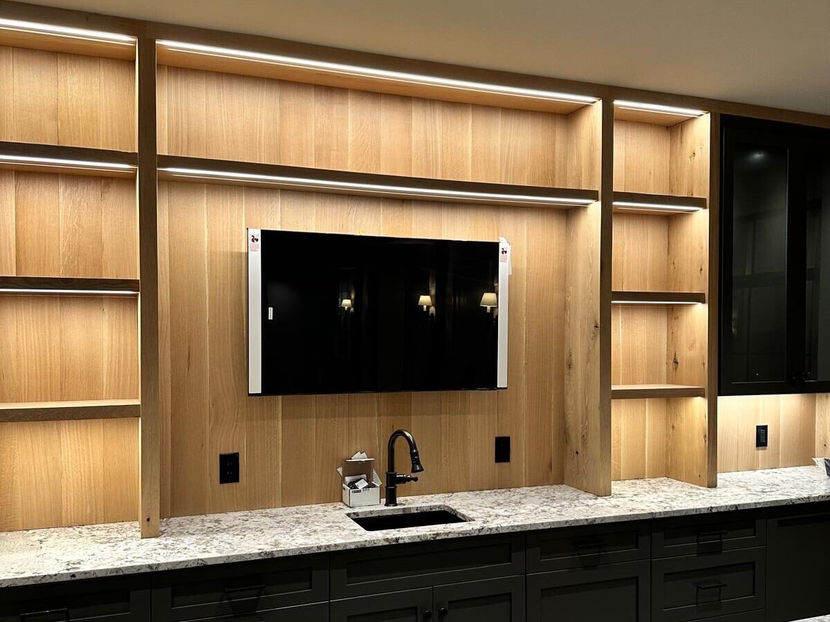 Wall mounted TV above a wet bar with LED lit white oak shelving, Upper Arlington OH